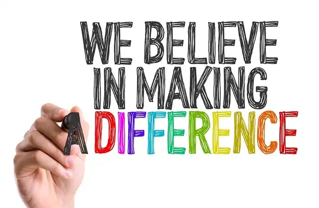 Hand with marker writing We Believe in Making a Difference